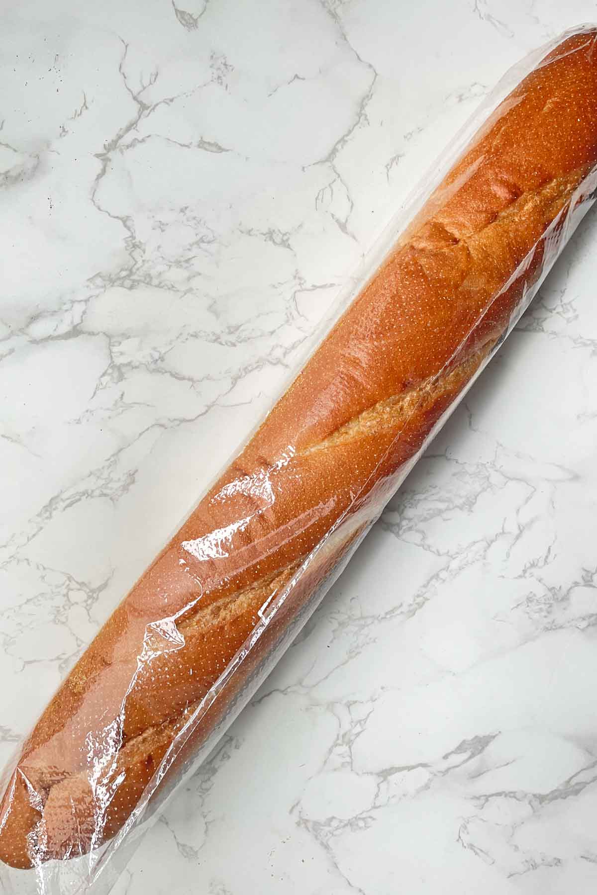 French bread baguette in plastic bag.