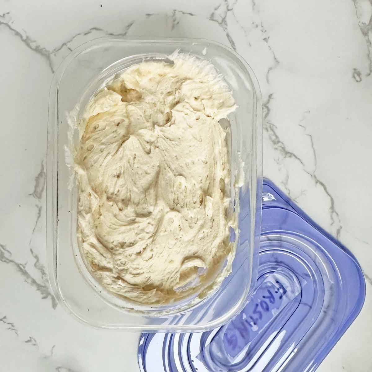 buttercream frosting in a container for freezing.