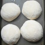 Frozen pizza dough in a tray.