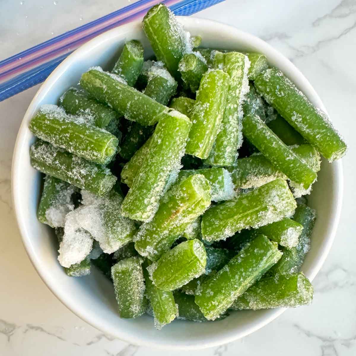 Frozen green beans in a bowl.